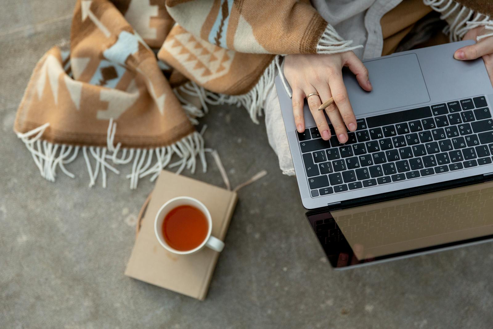 Crop unrecognizable freelancer typing on laptop during tea break